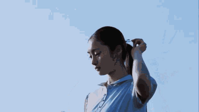 a woman in a blue shirt holds a bottle of water in her hand