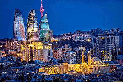 a city skyline at night with a mosque in the middle