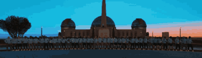 a group of people stand in front of a large building