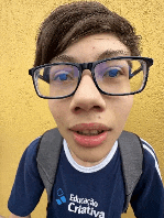 a boy wearing glasses and a blue shirt that says educacao criativa