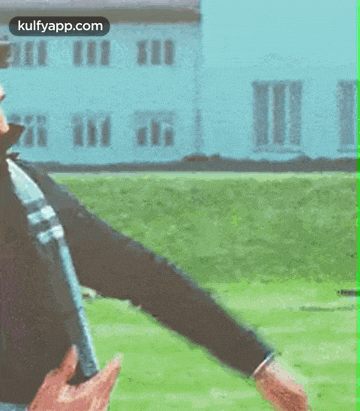 two men are standing next to each other on a grassy field .