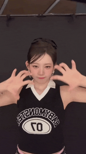 a woman wearing a black and white jersey with the word harmony on it is clapping her hands
