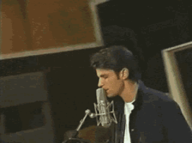 a close up of a man 's face with a microphone in his hand
