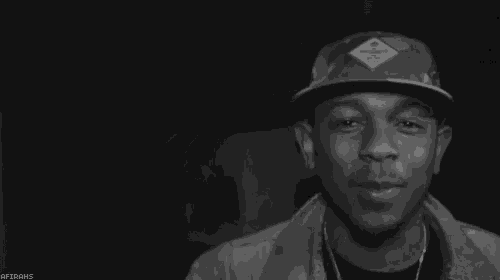 a black and white photo of a man wearing a hat and ear buds .