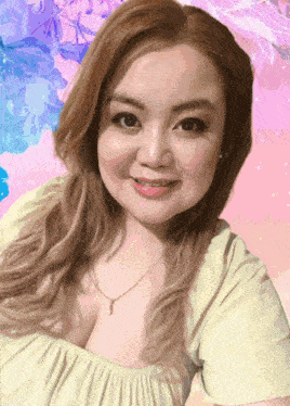 a woman wearing a yellow top and a pearl necklace