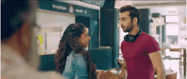 a man and a woman are standing next to each other and talking in a restaurant .