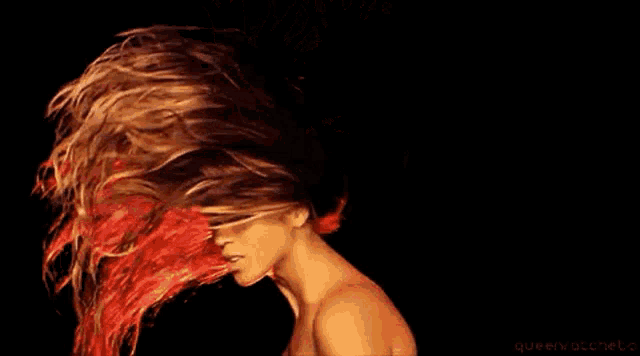a woman with long red hair is wearing a black top