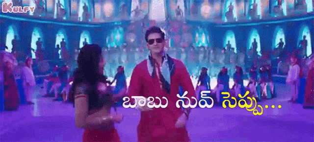a man and a woman are dancing in front of a crowd of people in a purple room .