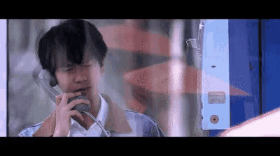 a man is talking on a pay phone in a booth .