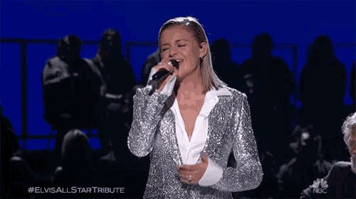 a woman singing into a microphone with the elvis all star tribute written on the bottom right