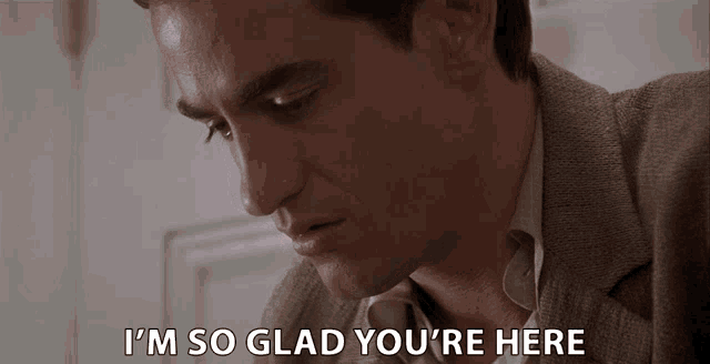 a man says " i 'm so glad you 're here " in front of a door