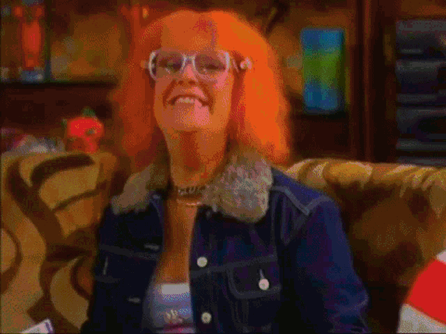 a woman with purple hair and glasses is smiling
