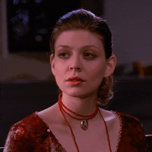a woman wearing a red dress and a red necklace