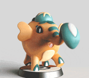 a figurine of an elephant with a blue hat on