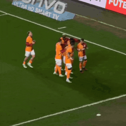 a soccer player with the number 42 on his back is hugging his teammates