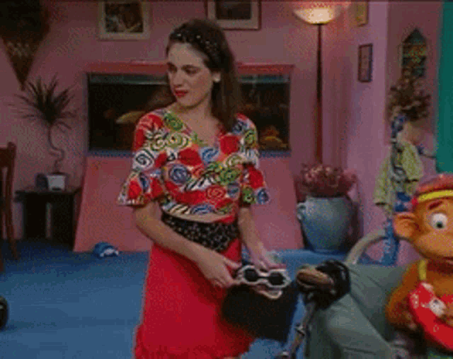 a woman in a red skirt is jumping on a couch in a living room
