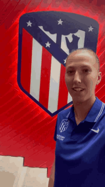 a man wearing a blue shirt that says atlético madrid