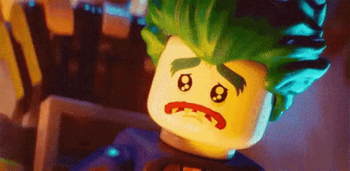a close up of a lego joker with a sad look on his face .