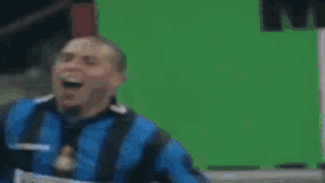 two soccer players wearing blue and black jerseys are celebrating a goal .