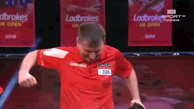 a man in a red shirt with the word ladbrokes on the front
