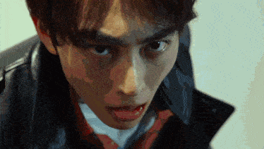 a close up of a man 's face with a black jacket