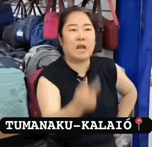 a woman is standing in front of a display of bags and making a funny face in a store .