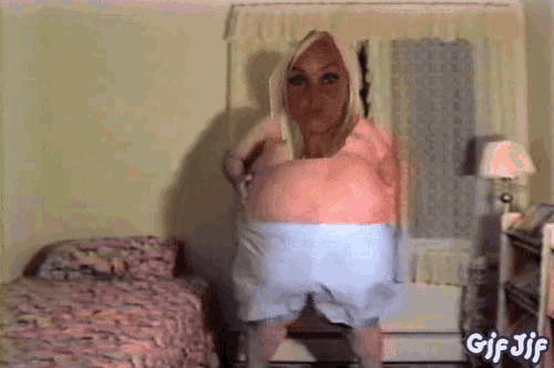 a gif of a woman standing in a bedroom with the words gif jif on the bottom right