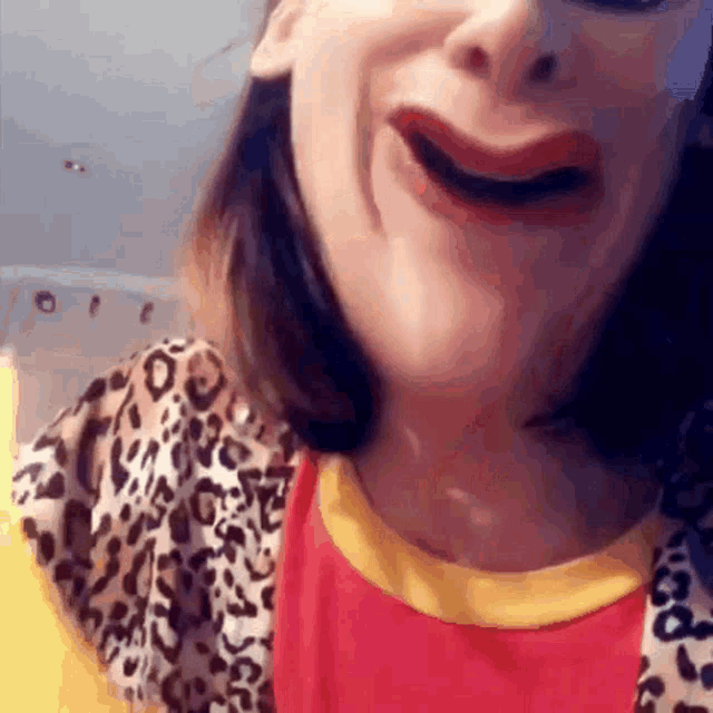 a close up of a woman 's face with a leopard print shirt on