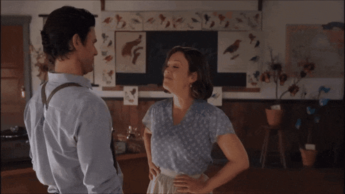 a man and a woman are standing in front of a blackboard that says ' birds ' on it