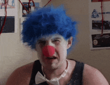 a man in a blue clown wig and red nose