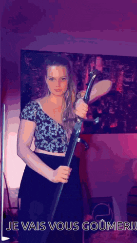 a woman is holding a sword with the words je vais vous goumer on the bottom