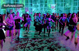 a large group of people are dancing together in a room .