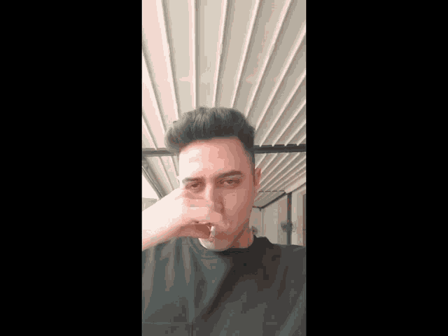 a man covering his nose with his hand while wearing a ring