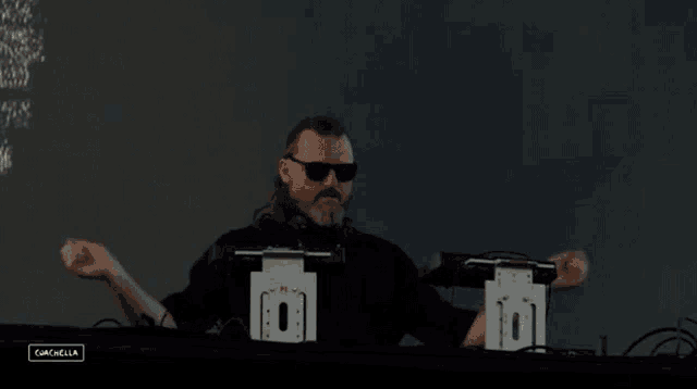 a man wearing sunglasses and headphones is playing music at a concert .