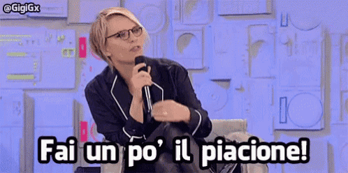 a woman with glasses is holding a microphone and saying fai un po ' il piacione