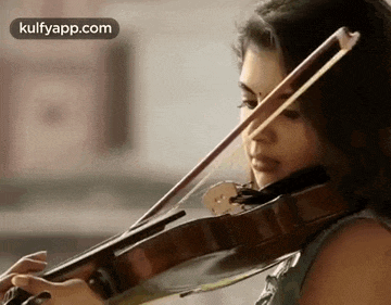 a woman is playing a violin with a bow in her hand .