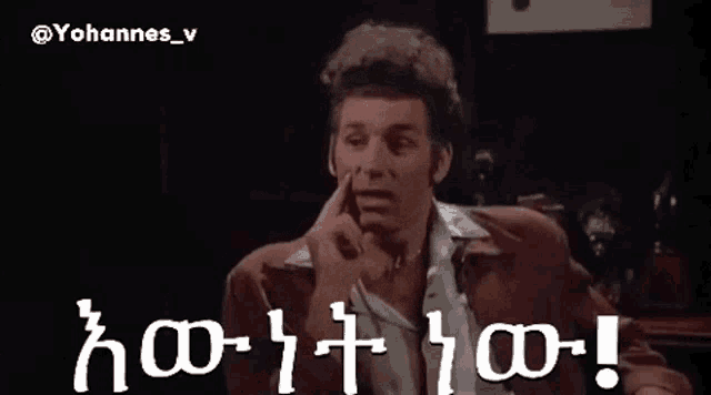 a man in a suit is pointing at something in a dark room with the words yohannes_v written on the bottom