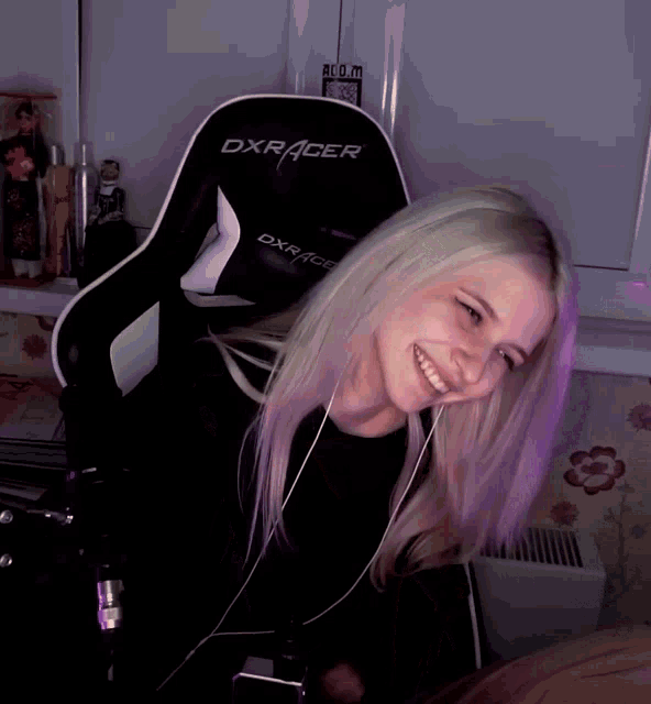 a woman is sitting in a dxracer chair