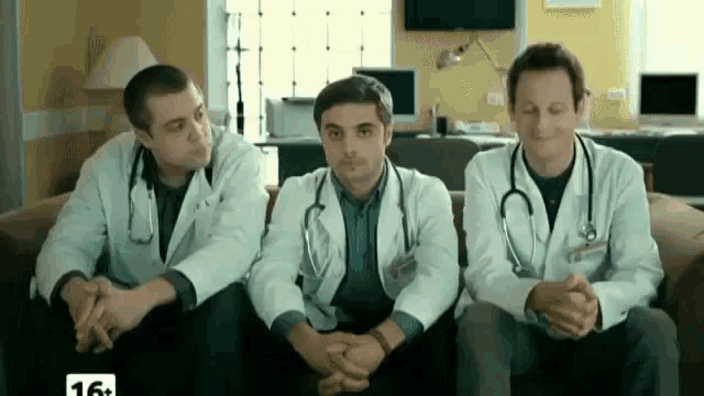 three doctors are sitting on a couch with the number 16 on the bottom right