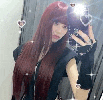 a woman with long red hair is taking a selfie in the mirror .