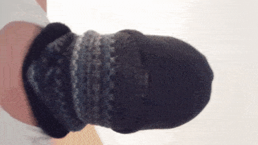 a person wearing a knitted hat and a knitted scarf around their neck