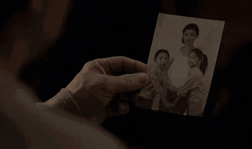 a person is holding a burning photo of a family