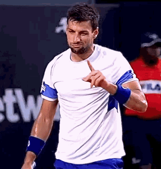 a man wearing a white shirt and blue shorts is giving a thumbs up sign