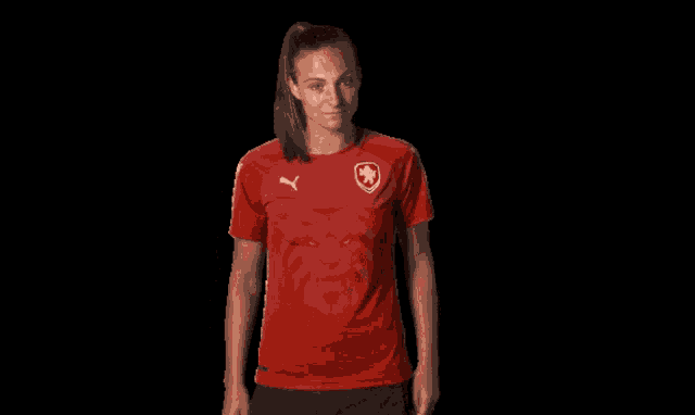 a woman in a red shirt with a puma logo on it
