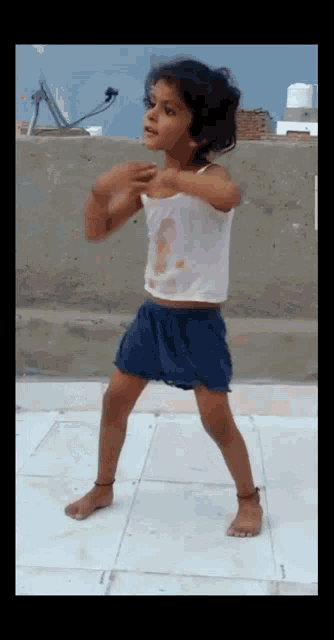 a little girl is dancing on a tiled floor