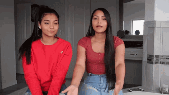 two women standing next to each other one wearing a red shirt with the letter j on it