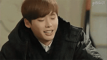 a young man wearing a black jacket is smiling and looking at the camera .