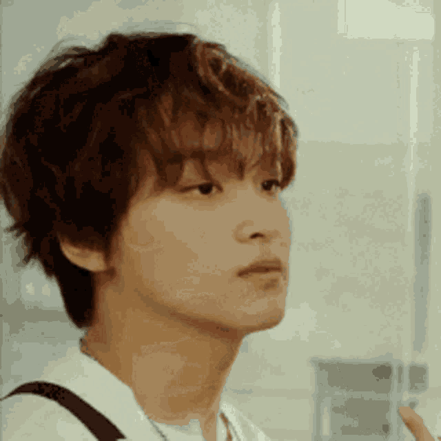a close up of a young man 's face with a backpack on .