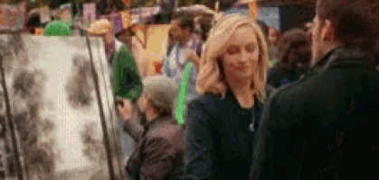 a man and a woman are standing in front of a crowd of people .
