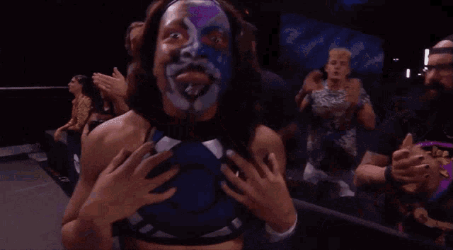 a wrestler with a purple and white face painted on her face